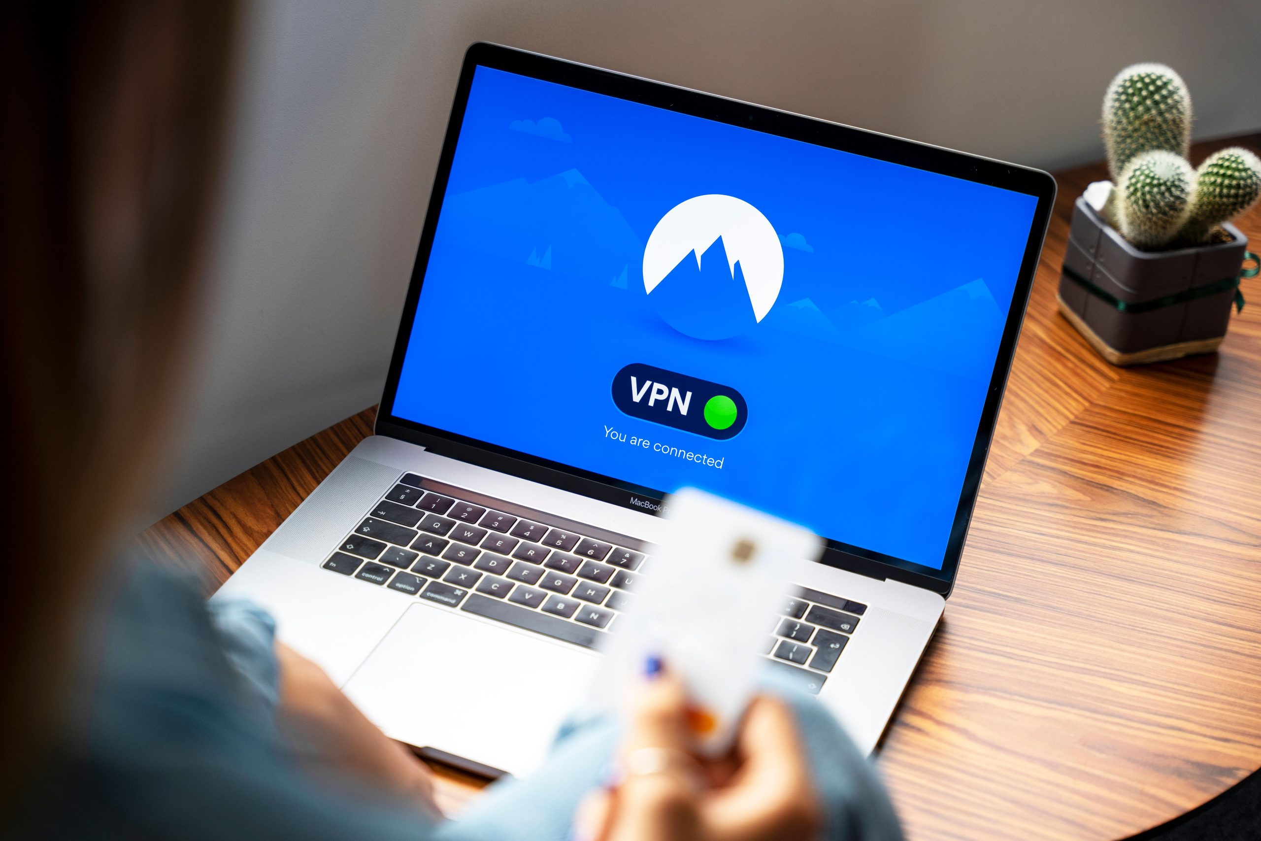 Online Anonymity Is Becoming a Service Feature, Not a Disguise Person using a VPN on a laptop for more private, secure internet browsing.