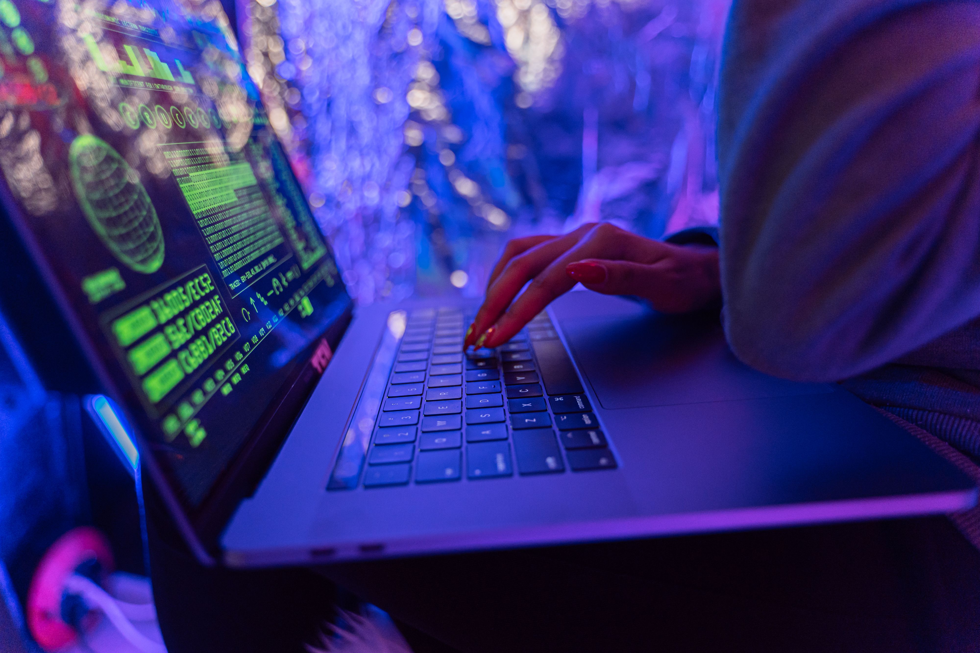 Hands typing on a laptop with cybersecurity graphics, suggesting encrypted and secure digital communication.